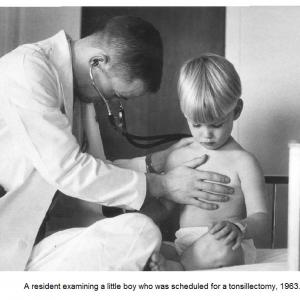 A medical resident examining a little boy, 1963
